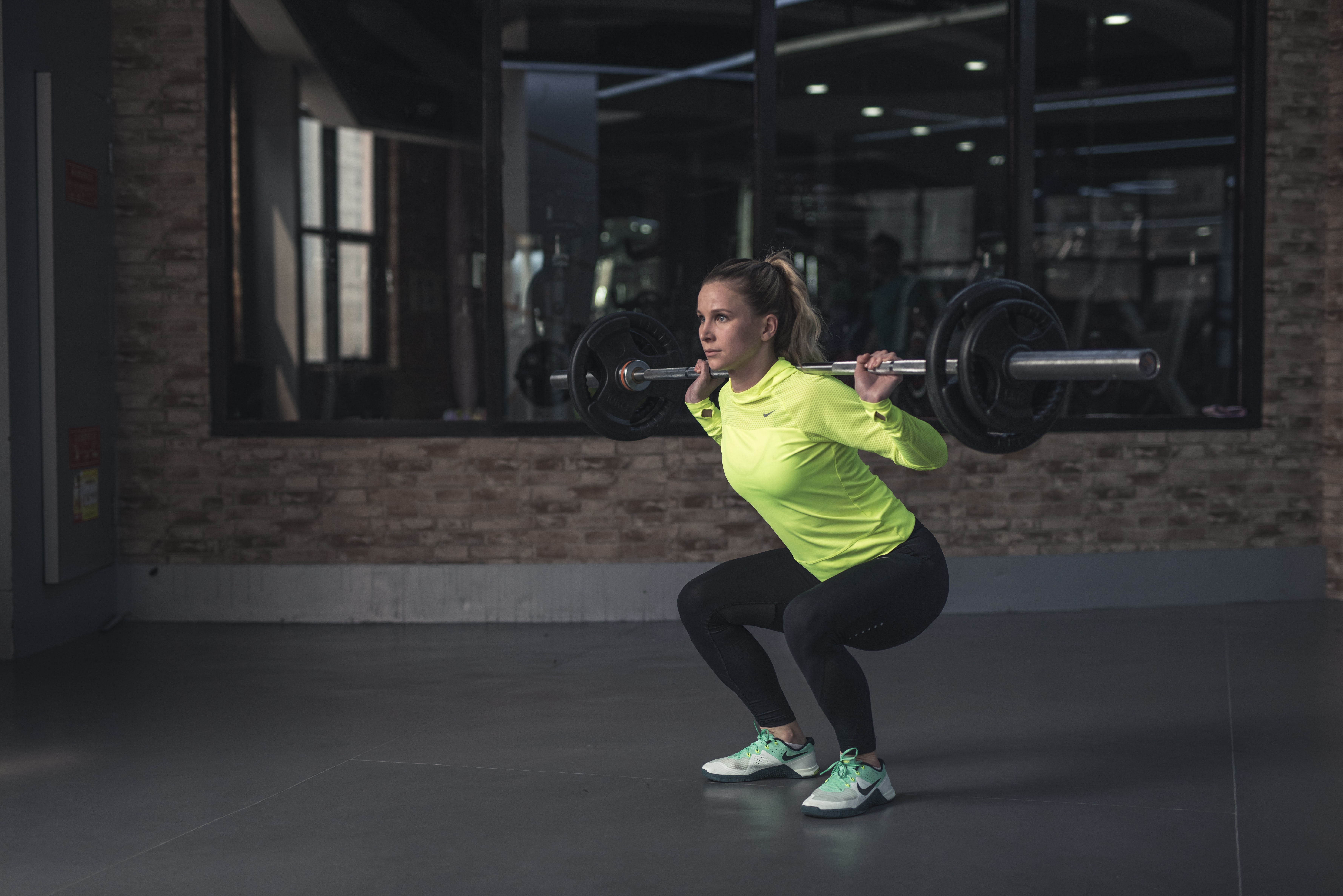 a woman performing a squat with a barbell